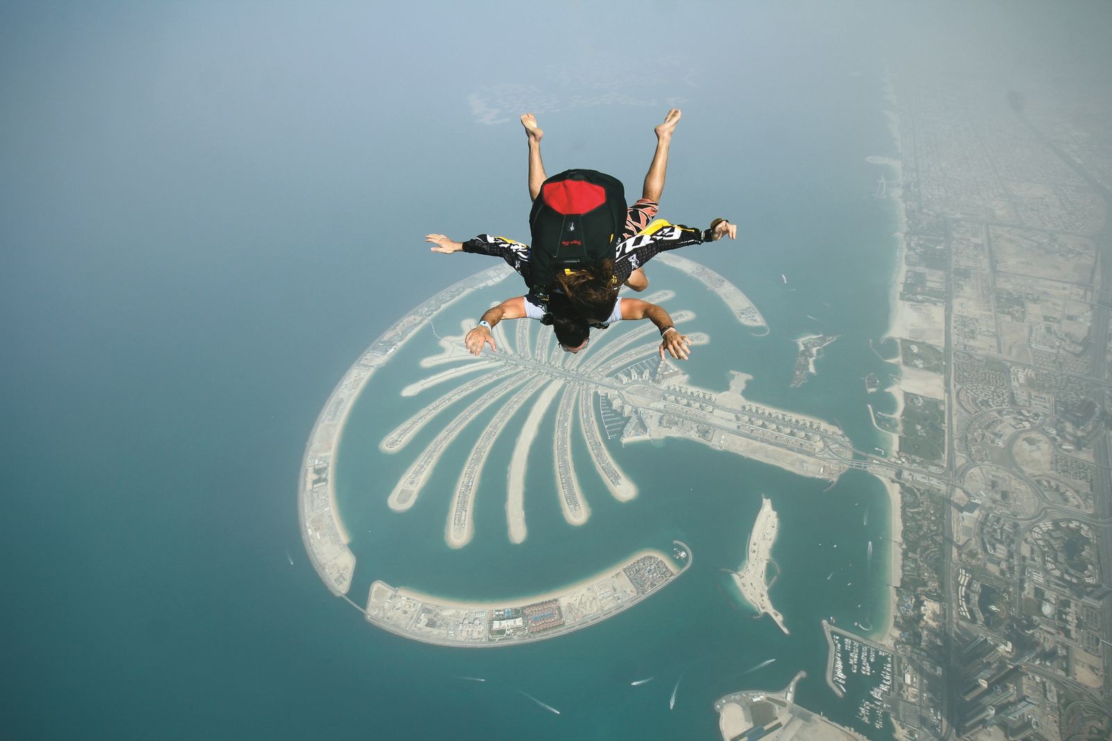 Tandem skydivers in freefall above Palm Jumeirah in Dubai